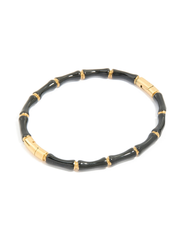 Featuring a waterproof gold plated stainless steel black enamel bamboo bangle with statement styling in front view