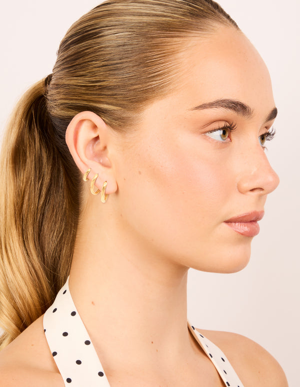 Displaying small wrap huggie earrings with waterproof gold plated stainless steel in a 3-pack on model view