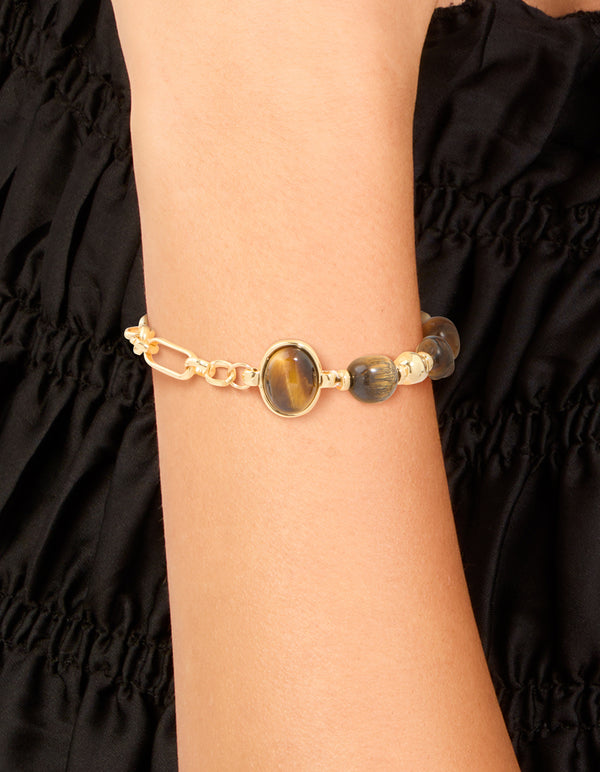 Featuring a waterproof gold plated stainless steel bracelet with beads, and tigers eye semi precious stone in brown on wrist view