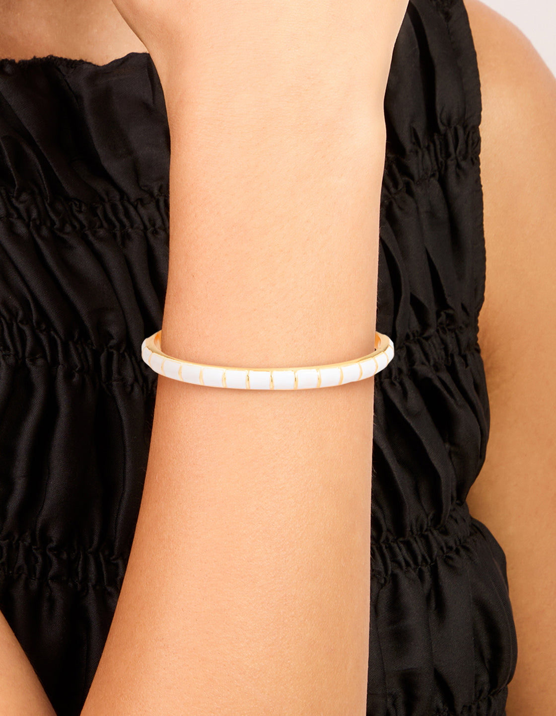 Featuring a waterproof bangle with stainless steel construction, white enamel bamboo pattern, and gold plated detailing on wrist view