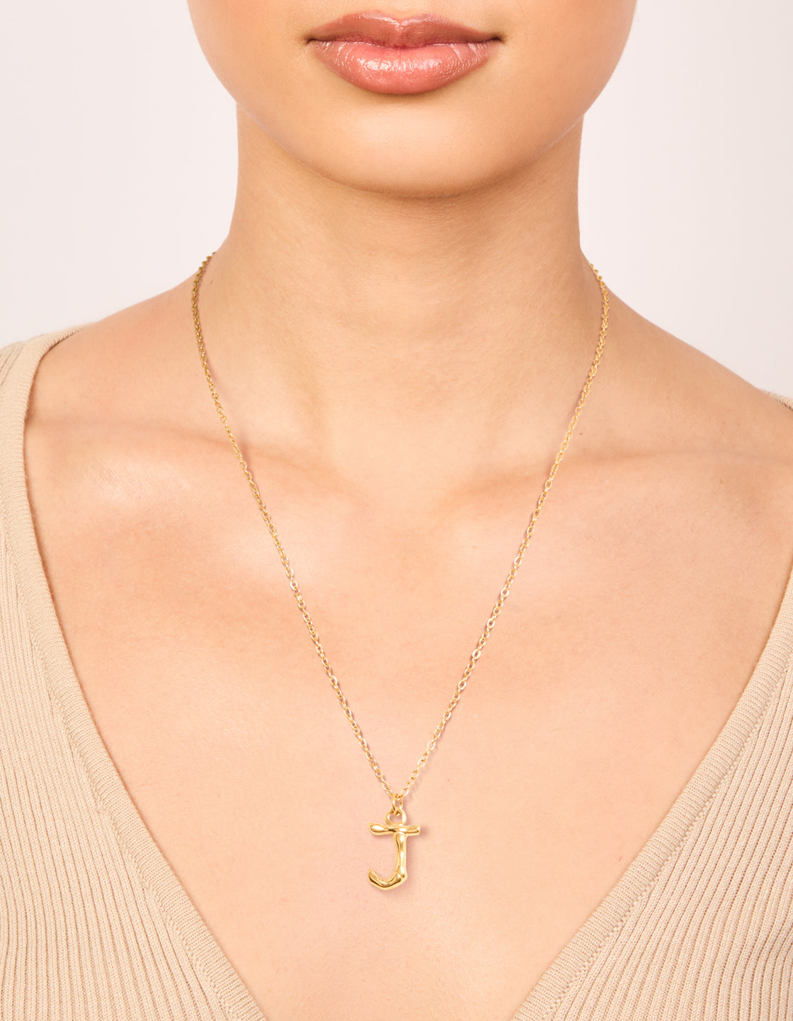 Displayed on neck is a waterproof letter J necklace with initial pendant in bamboo style, gold plated stainless steel on neck view