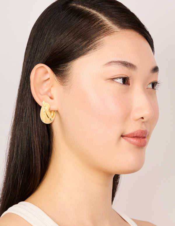 Crafted from waterproof gold plated stainless steel medium illusion hoop earrings with statement style on model view
