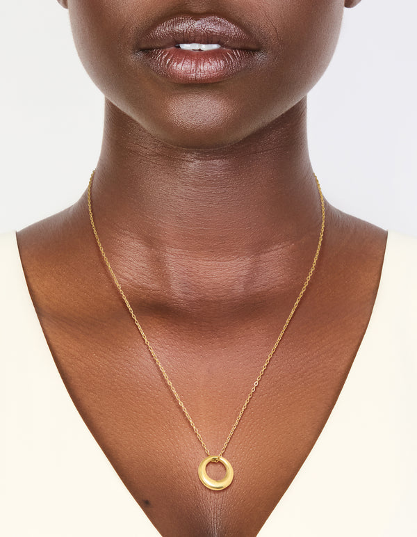 Showcasing a waterproof disc pendant necklace crafted from gold plated stainless steel on neck view