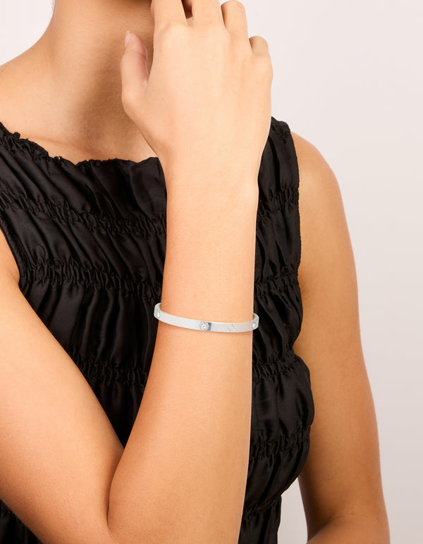 Showcasing a waterproof stainless steel cubic zirconia flower bangle in silver on wrist view