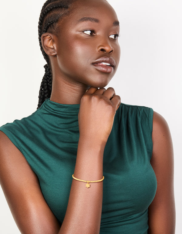 Designed with waterproof gold plated stainless steel, this stretch bracelet showcases beads and flower on model view
