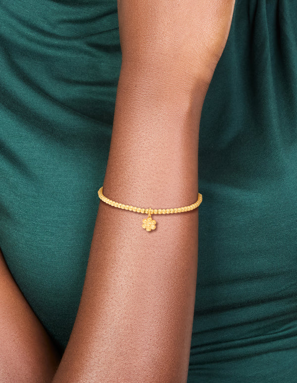 Featuring a waterproof gold plated stainless steel stretch bracelet with beads and flower on wrist view