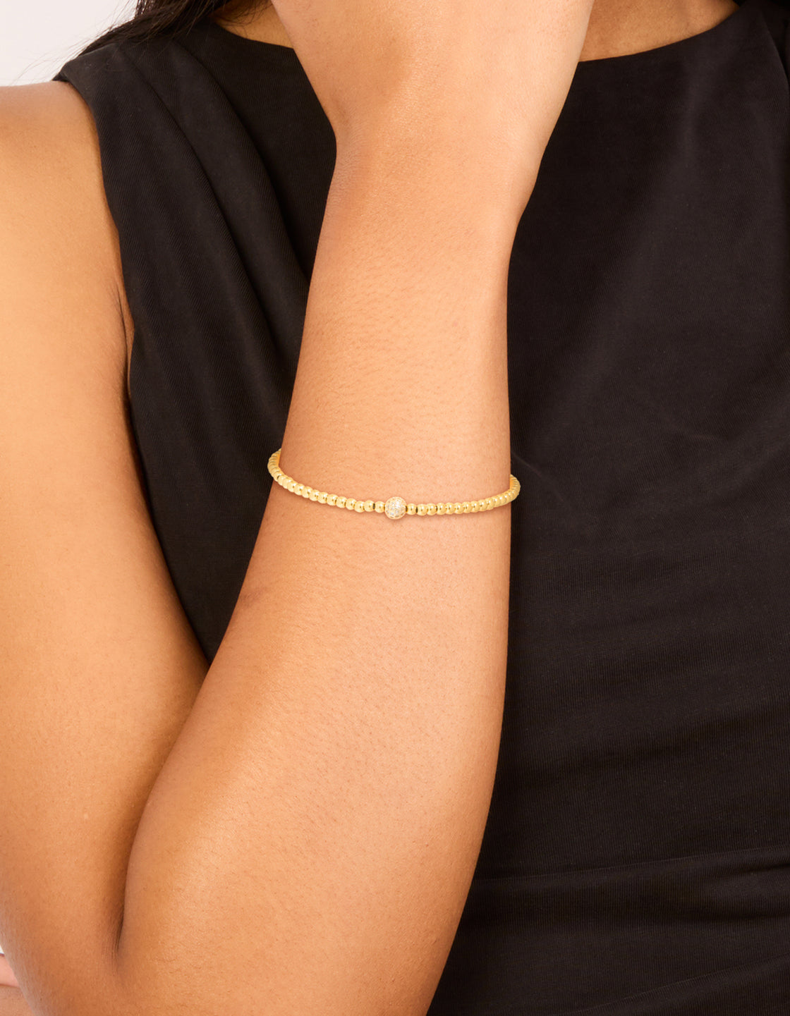 Showcasing a waterproof gold plated stainless steel cubic zirconia ball tennis stretch bracelet with beaded design on wrist view