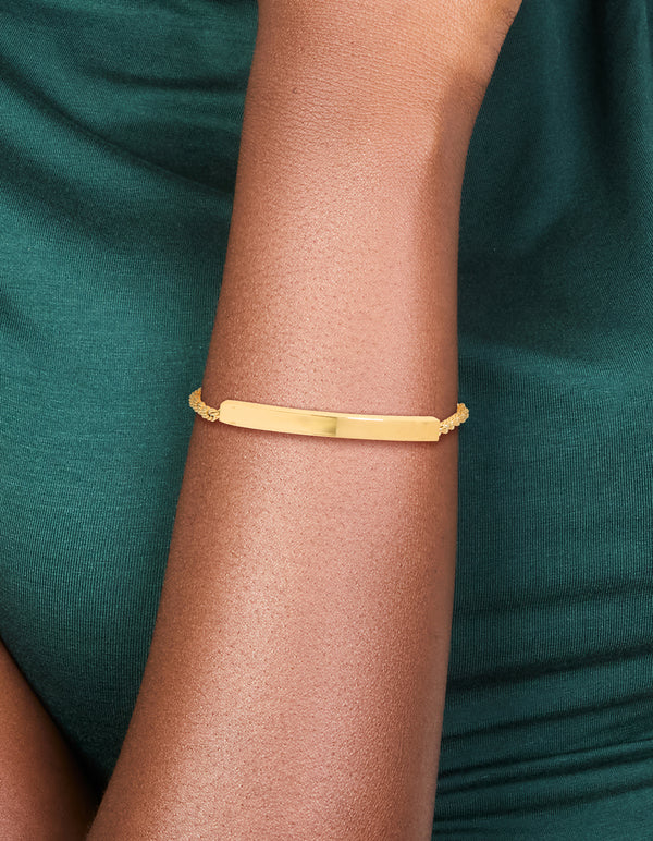 Showcasing a waterproof gold plated stainless steel twist engravable bar toggle bracelet on wrist view