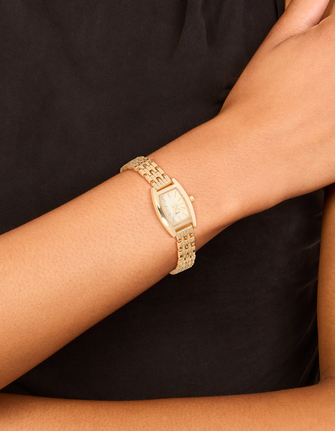 Showcasing a gold mini analog watch with white dial, link band strap, designed for women and formal occasions on wrist view
