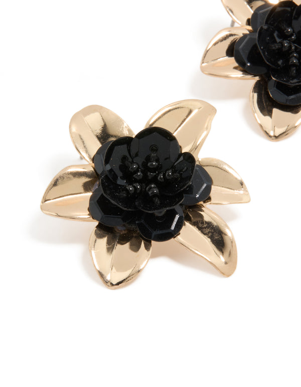 Showcasing statement stud earrings with beaded floral design in gold and black close up view