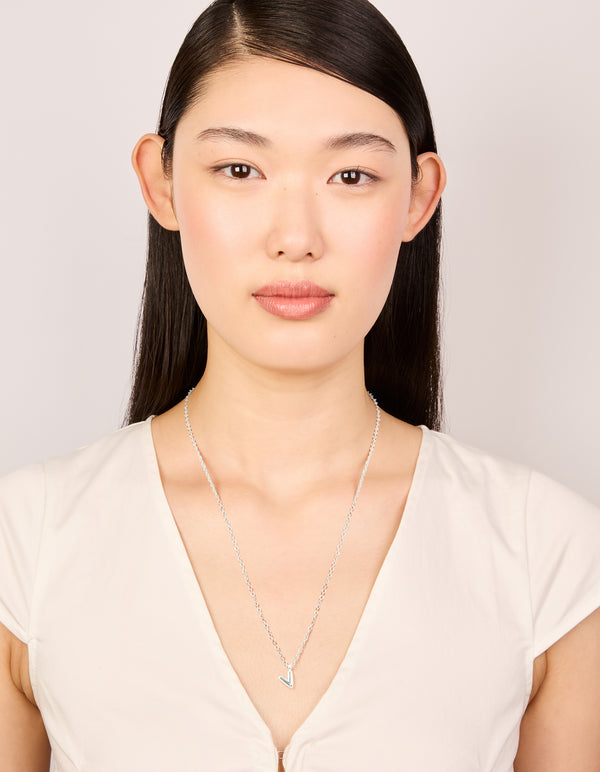 Crafted from waterproof stainless steel mini bubble letter V necklace with initial pendant in silver on model view