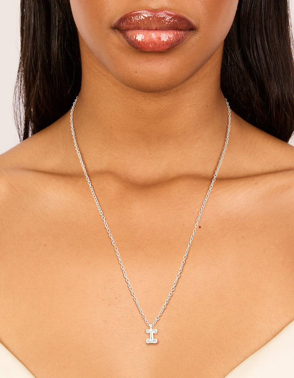 Showcasing a bubble letter I initial pendant necklace in waterproof stainless steel with silver finish on neck view