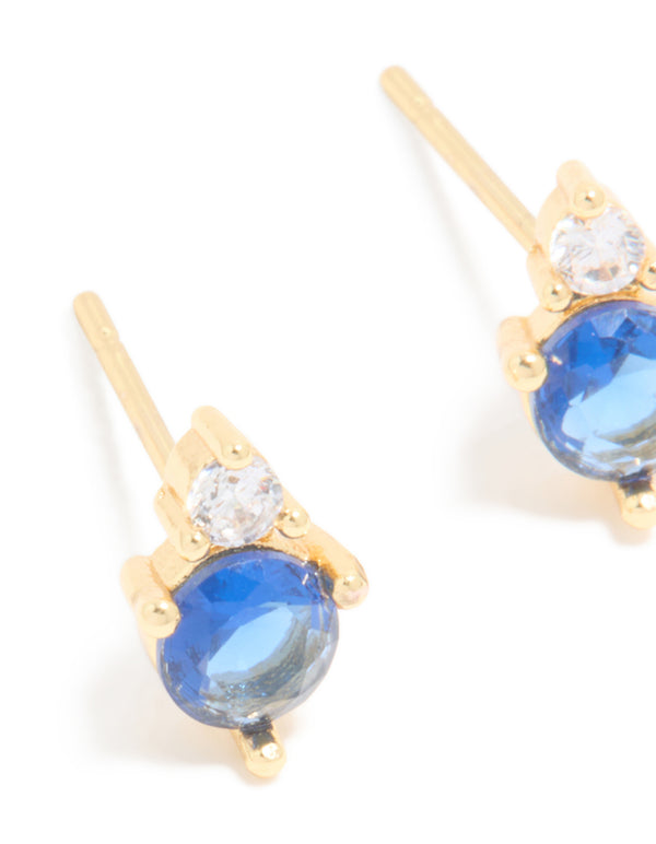 Crafted from waterproof gold plated stainless steel with cubic zirconia duo September birthstone stud earrings in royal blue and clear close up view