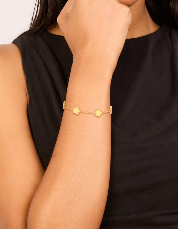 Showcasing a waterproof gold plated stainless steel butter yellow flowers charm bracelet in a dainty style on wrist view