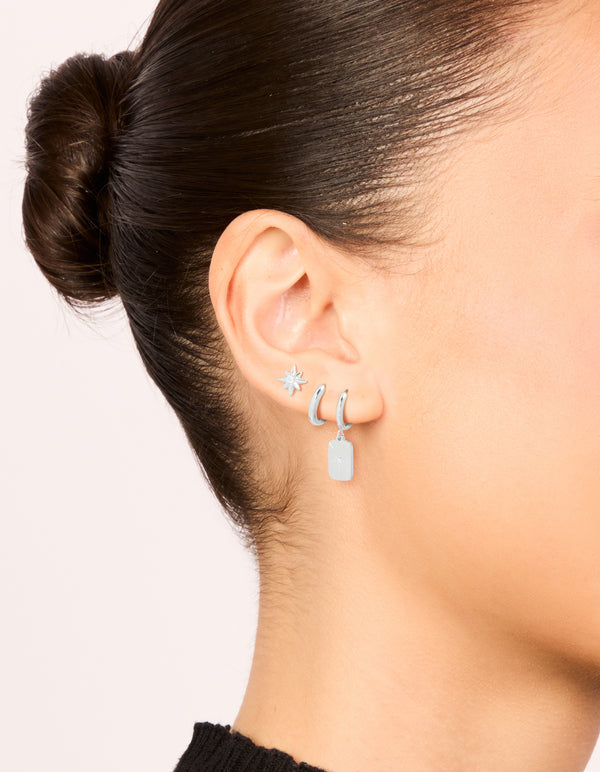Showcasing waterproof stainless steel star and disc earrings in a 3-pack featuring celestial with stud and huggie closure in silver on ear view