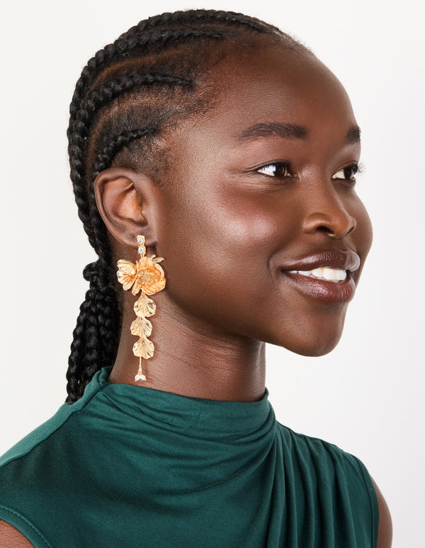 Elegant gold long floral drop earrings designed with leaf and pearl accents on model view
