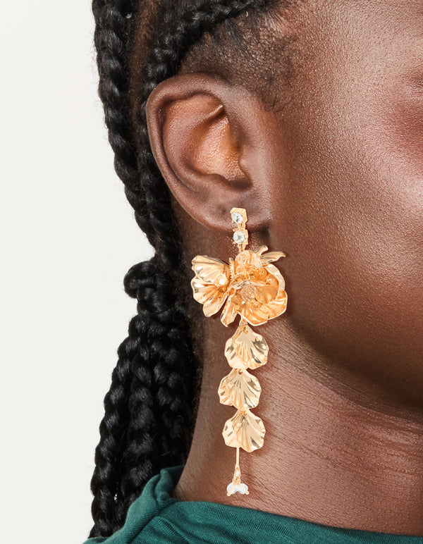 Beautifully crafted gold long floral drop earrings featuring leaf and beads accents on ear view