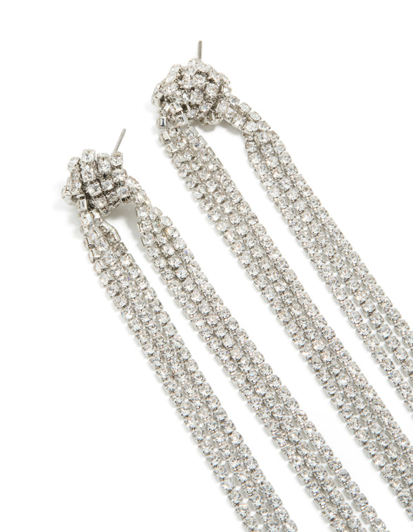 Designed with diamante knot detail, these silver tassel drop statement earrings close up view