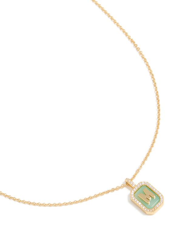Featuring a gold plated brass cubic zirconia letter M tag necklace with initials pendant close up view