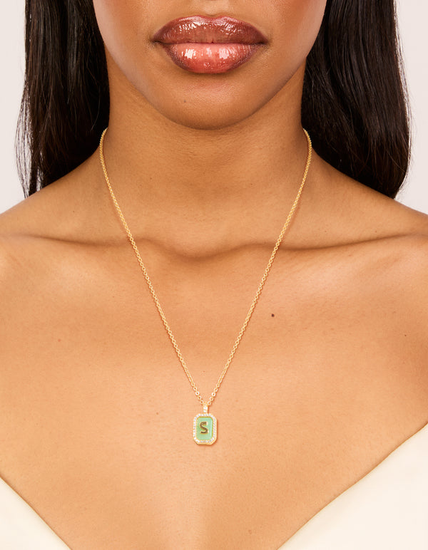 Showcasing a gold plated brass cubic zirconia letter S tag necklace with initials pendant on neck view