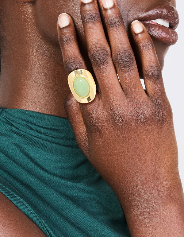 Elegant gold plated ring with oval pale green semi precious stone on finger view