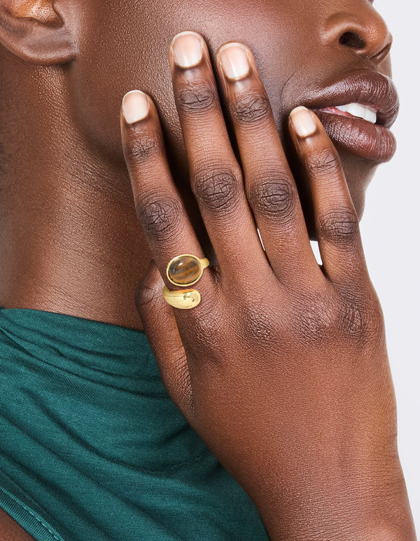 Crafted from waterproof gold plated stainless steel tigers eye round stone wrap ring on finger view