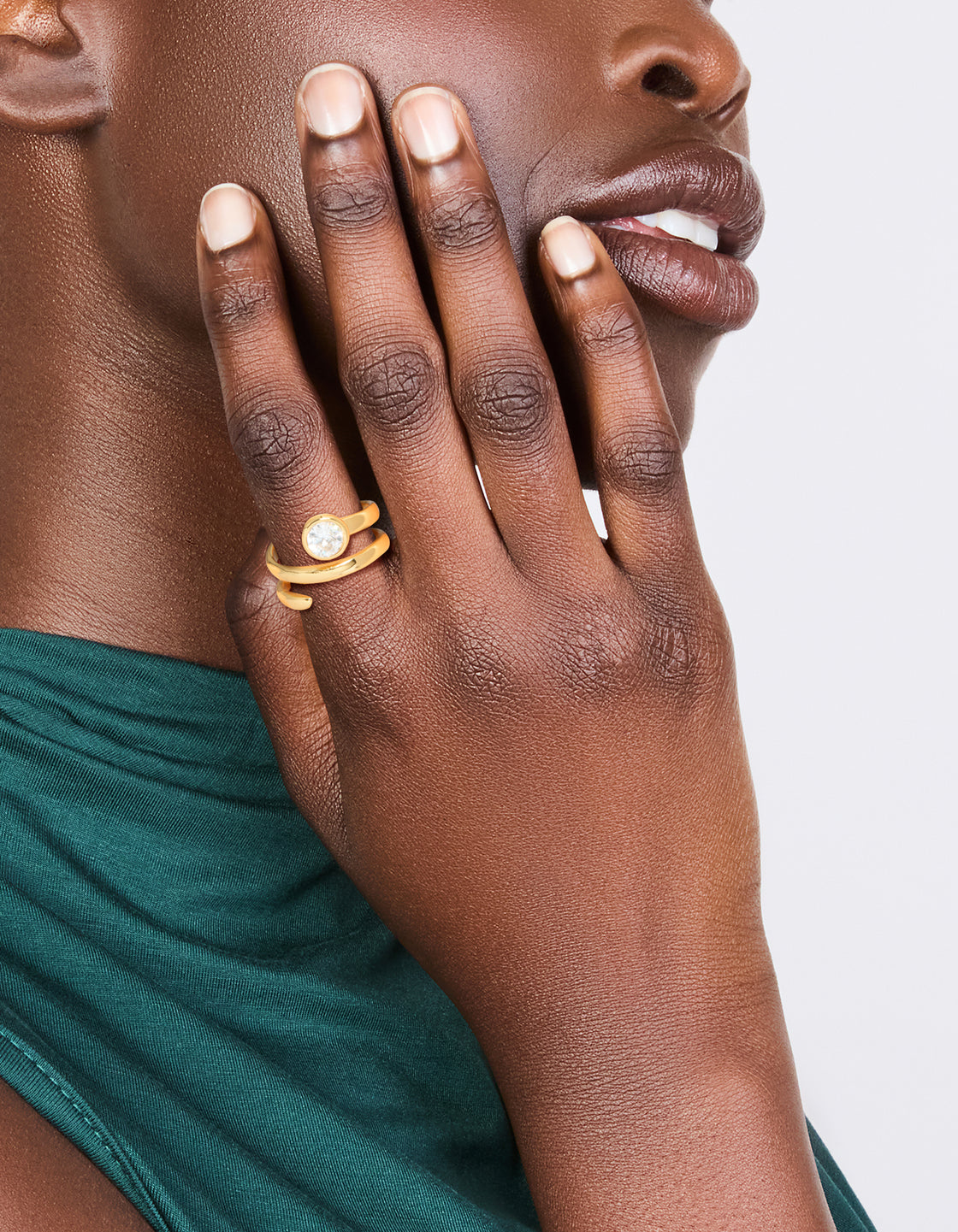 Showcasing a waterproof gold plated stainless steel diamante swirl ring with clear accents on finger view