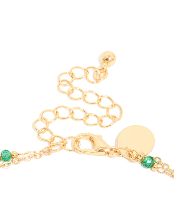 Highlighting the clasp mechanism in this gold plated layered necklace with beads, emerald stone and pearl accents clasp detail view