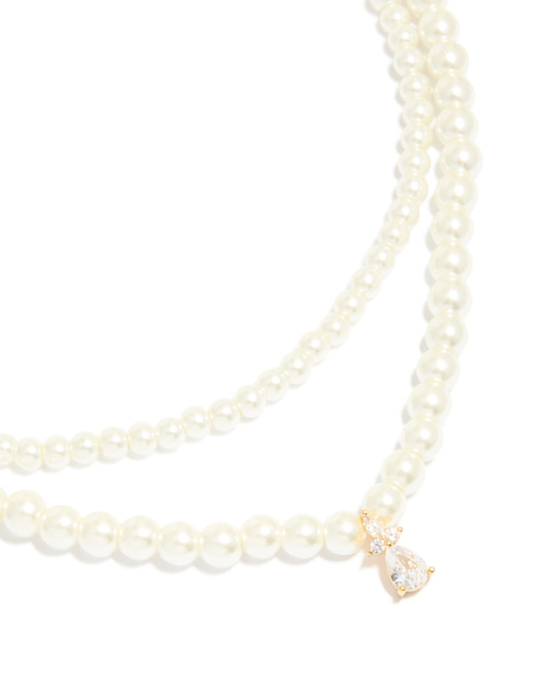Featuring a gold plated cubic zirconia and pearl drop layered necklace close up view