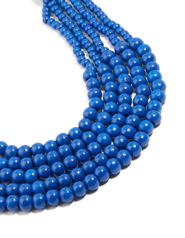 Beautiful dark blue acrylic beaded long layered necklace featuring royal statement in gold close up view