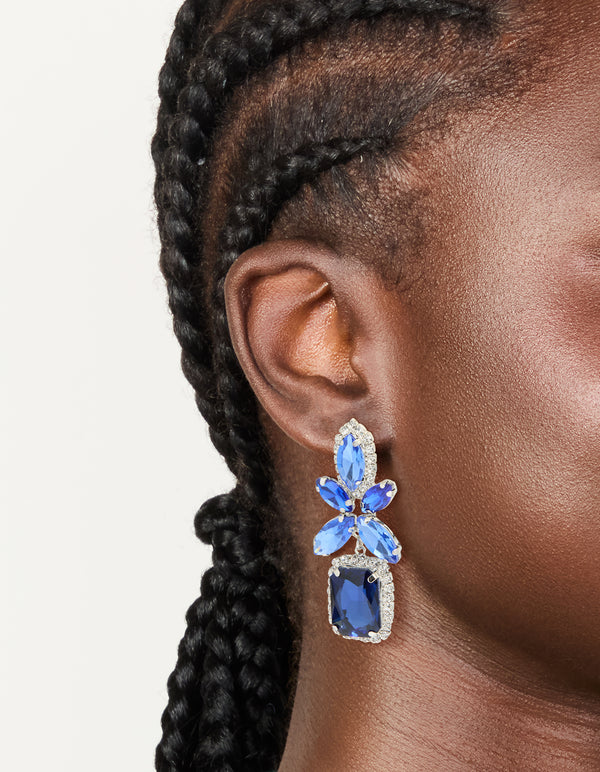 Showcasing silver blue diamante square flower drop earrings with floral design on ear view