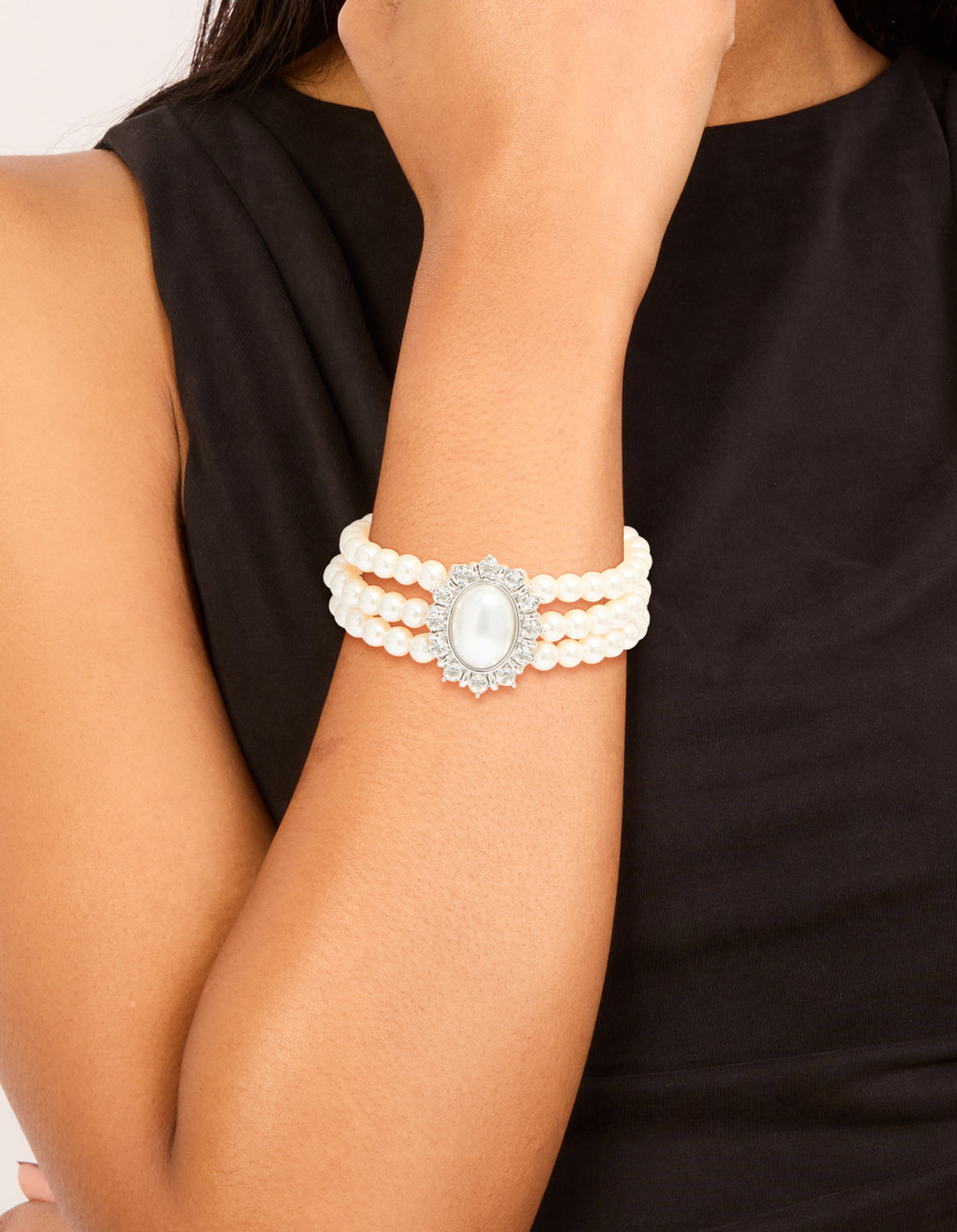 Showcasing a silver diamante and pearl layered bracelet on wrist view