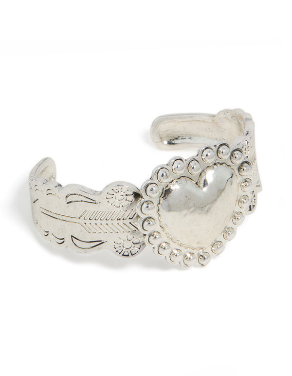 Featuring a silver boho heart wrist cuff with floral engravings and statement design in front view