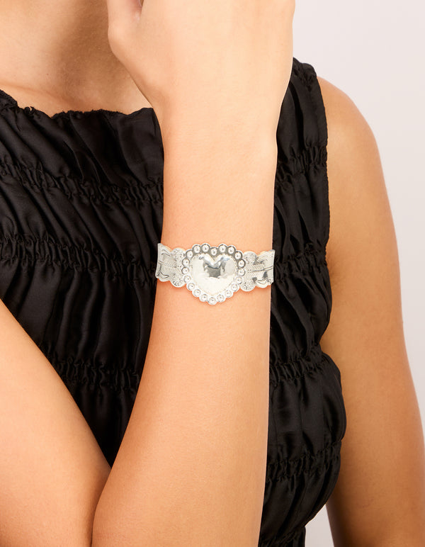 Showcasing a silver boho heart wrist cuff featuring floral details and statement styling on wrist view