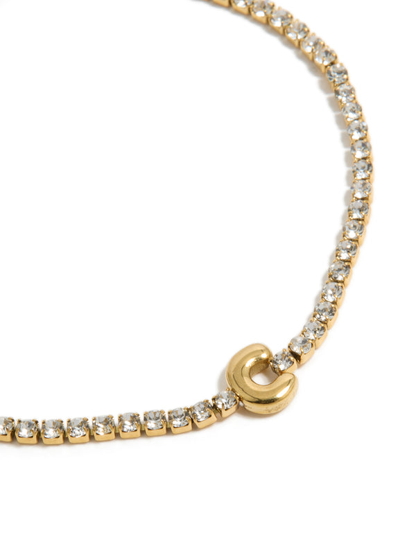 Highlighting the letter C initial detail on a waterproof gold plated stainless steel tennis bracelet with cubic zirconia stones in close up view