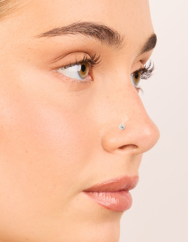 Showcasing titanium bezel cubic zirconia threadless flat back nose studs with ball accents in silver nose view
