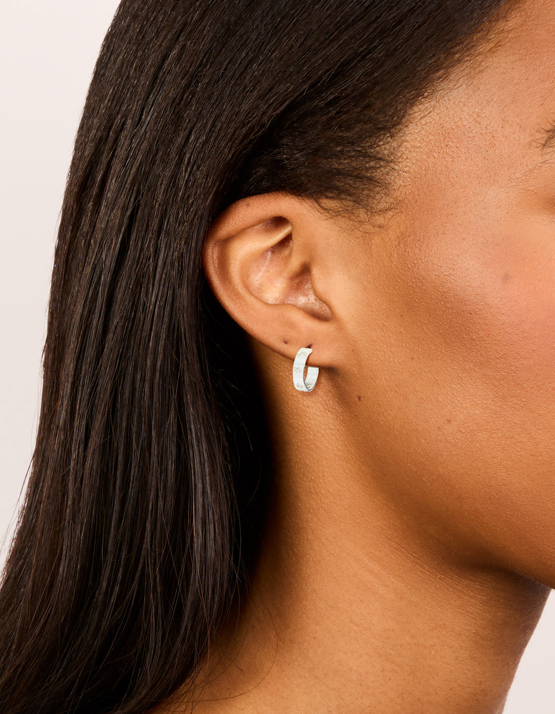 Showcasing waterproof stainless steel square cubic zirconia hoop earrings in silver on ear view