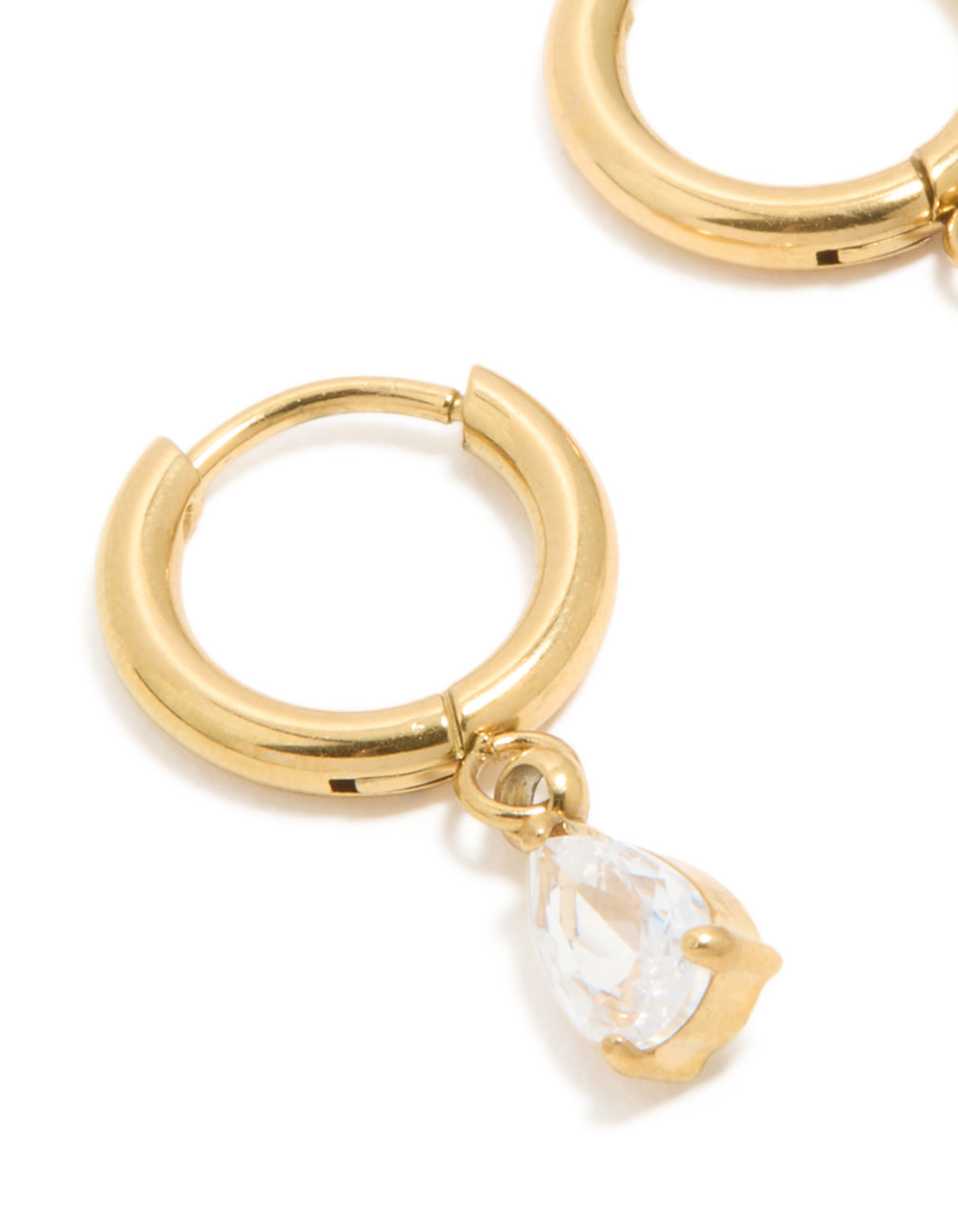 Crafted from waterproof gold plated stainless steel, featuring pear cut cubic zirconia charm huggie earrings close up view