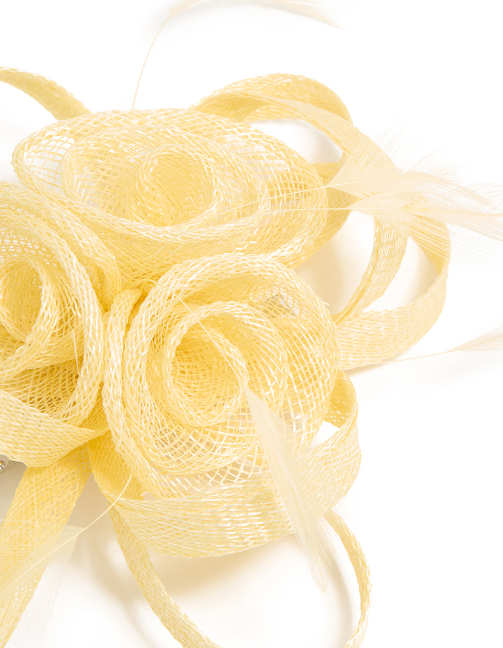 Elegant yellow sinamay fabric swirl and feather hair clip featuring floral accents, side view