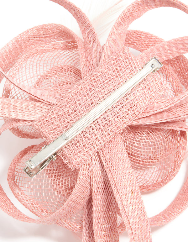 Featuring a sinamay fabric swirl hair clip with feathers and floral accents in light pink detail view