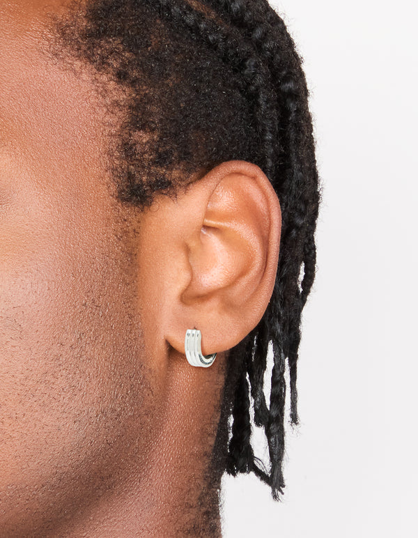 Showcasing mens waterproof ribbed huggie earrings crafted from stainless steel in silver on ear view
