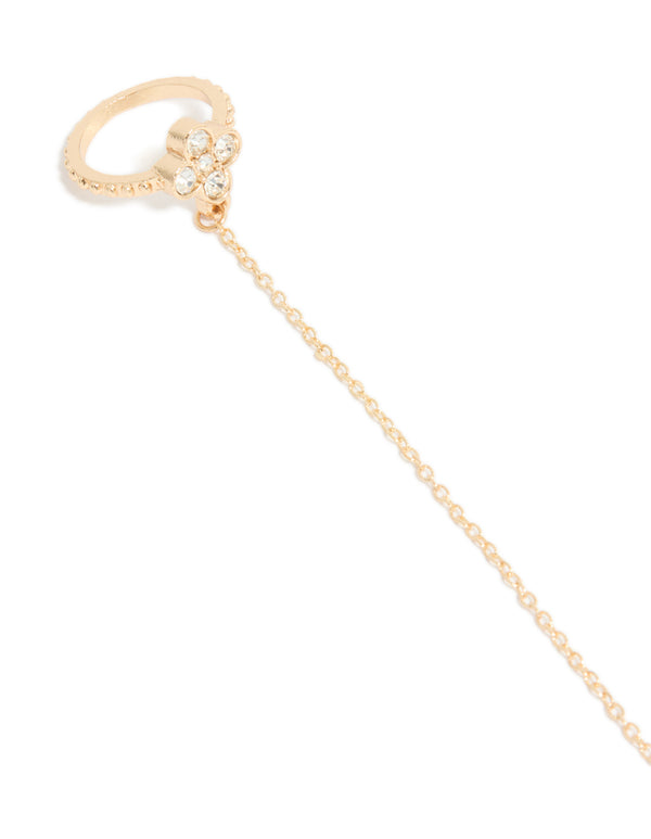 Featuring a gold diamante flower and fixed ring hand chain in dainty statement style close up view