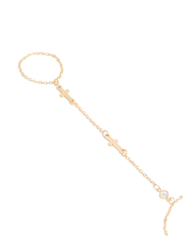 Showcasing a gold hand chain bracelet featuring cross details with close up view