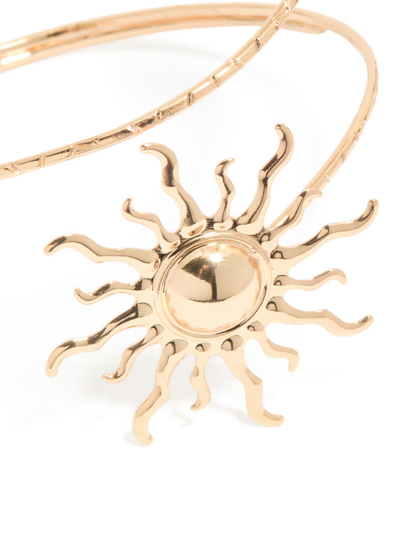 Crafted from gold, this double sun arm cuff features celestial motifs in a statement style in close up view