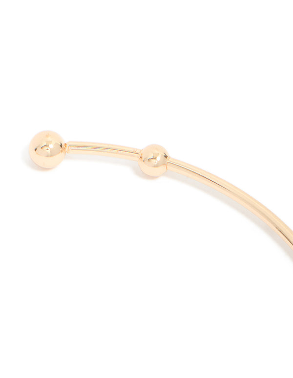 Crafted from gold with celestial charms featuring sun, moon, and star in statement style in close up view