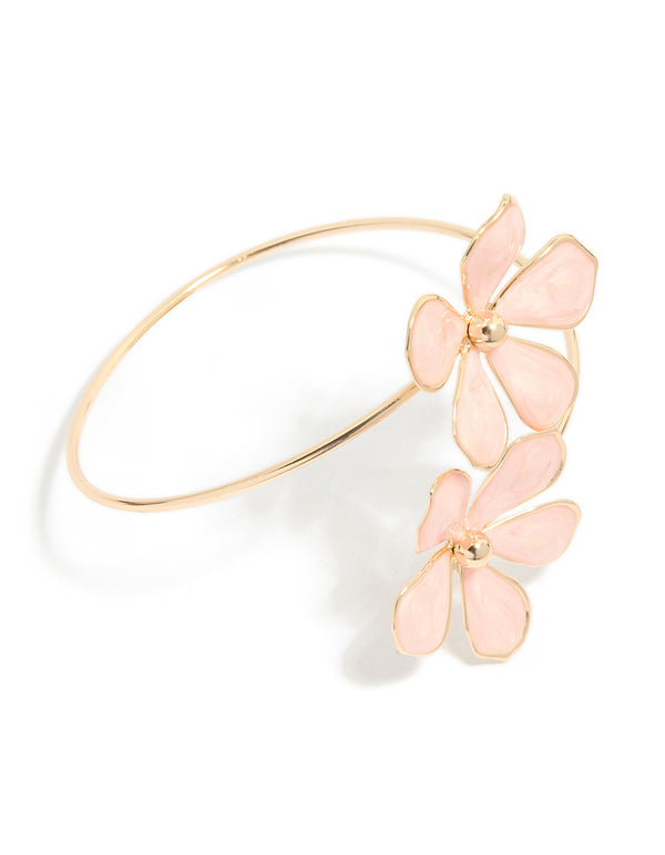 Showcasing a statement arm cuff featuring light pink enamel floral pattern in gold front view
