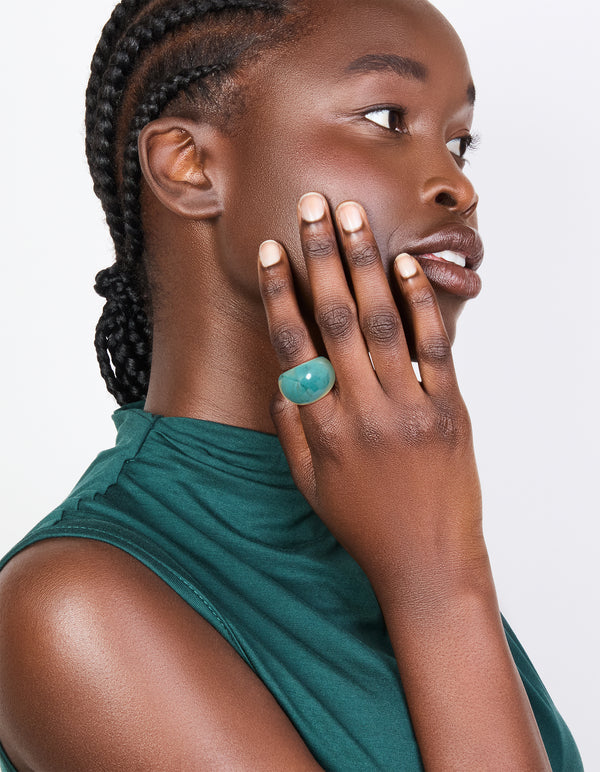 Showcasing turquoise acrylic and shell rings in a stackable statement 3-pack with ocean-inspired on finger view