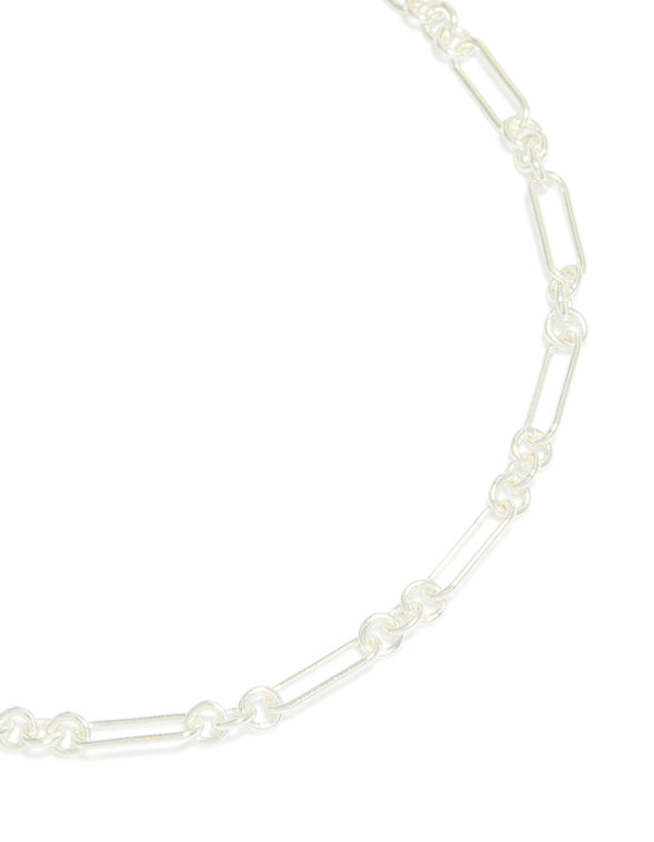 A silver plated long figaro chain necklace features intricate link details close up view