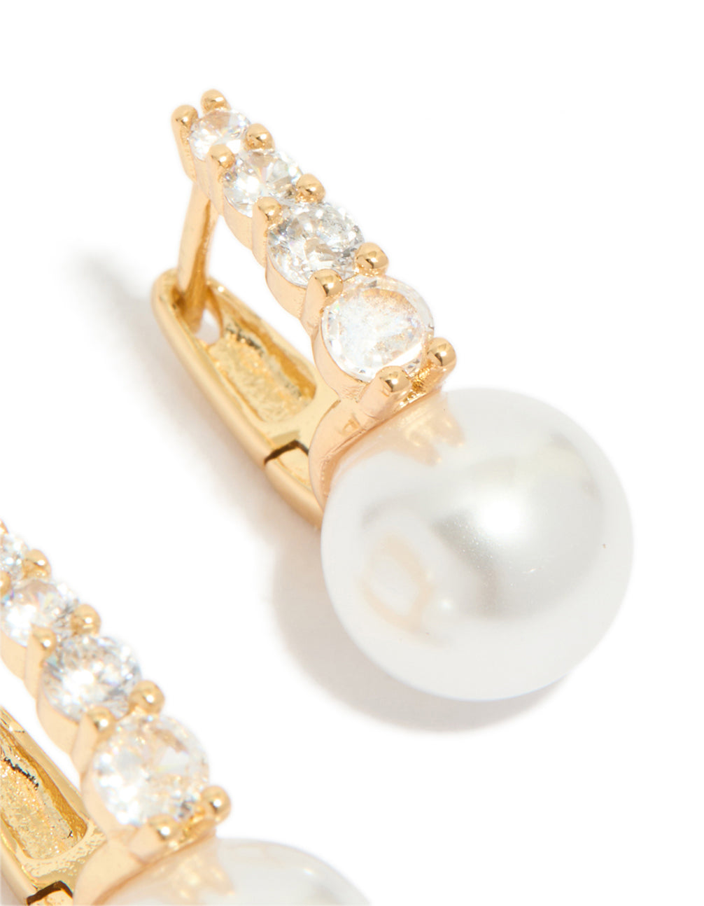 Dainty gold plated huggie earrings featuring cubic zirconia and pearl post detail view