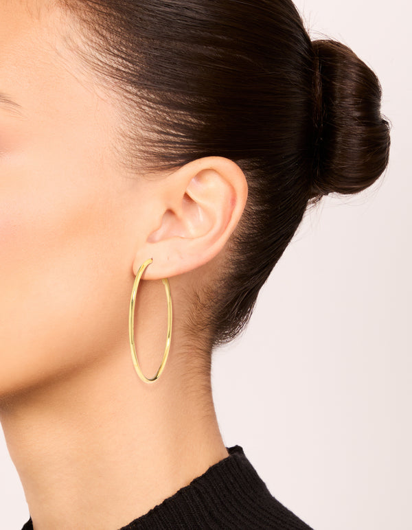 Showcasing gold plated thin hoop earrings on ear view